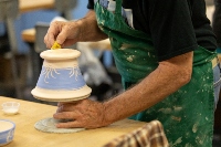 Hands sculpting a pot