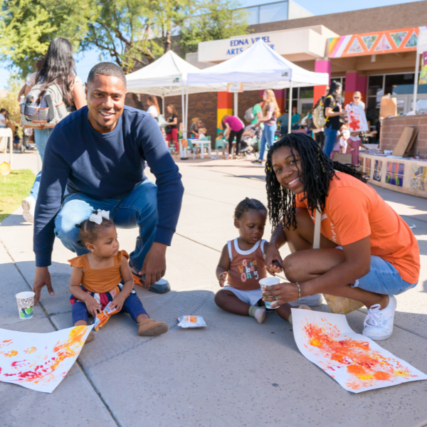 A family of four poses in front of their art projects.