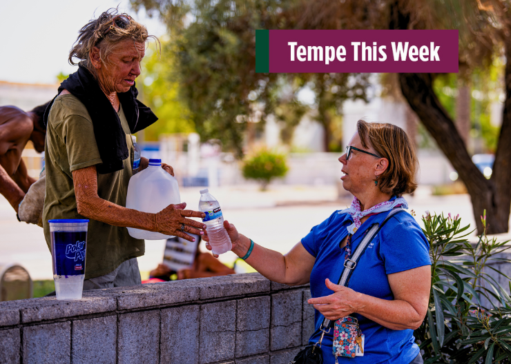 Two people exchange a water bottle during a point-in-time homeless count.